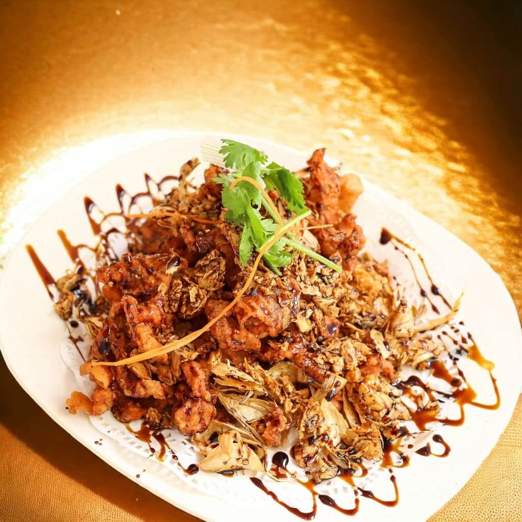 Delicious fried pork with garlic served on a plate, accompanied by a flavorful sauce and garnished to perfection. Jia Wang Cafe Zi Char Special